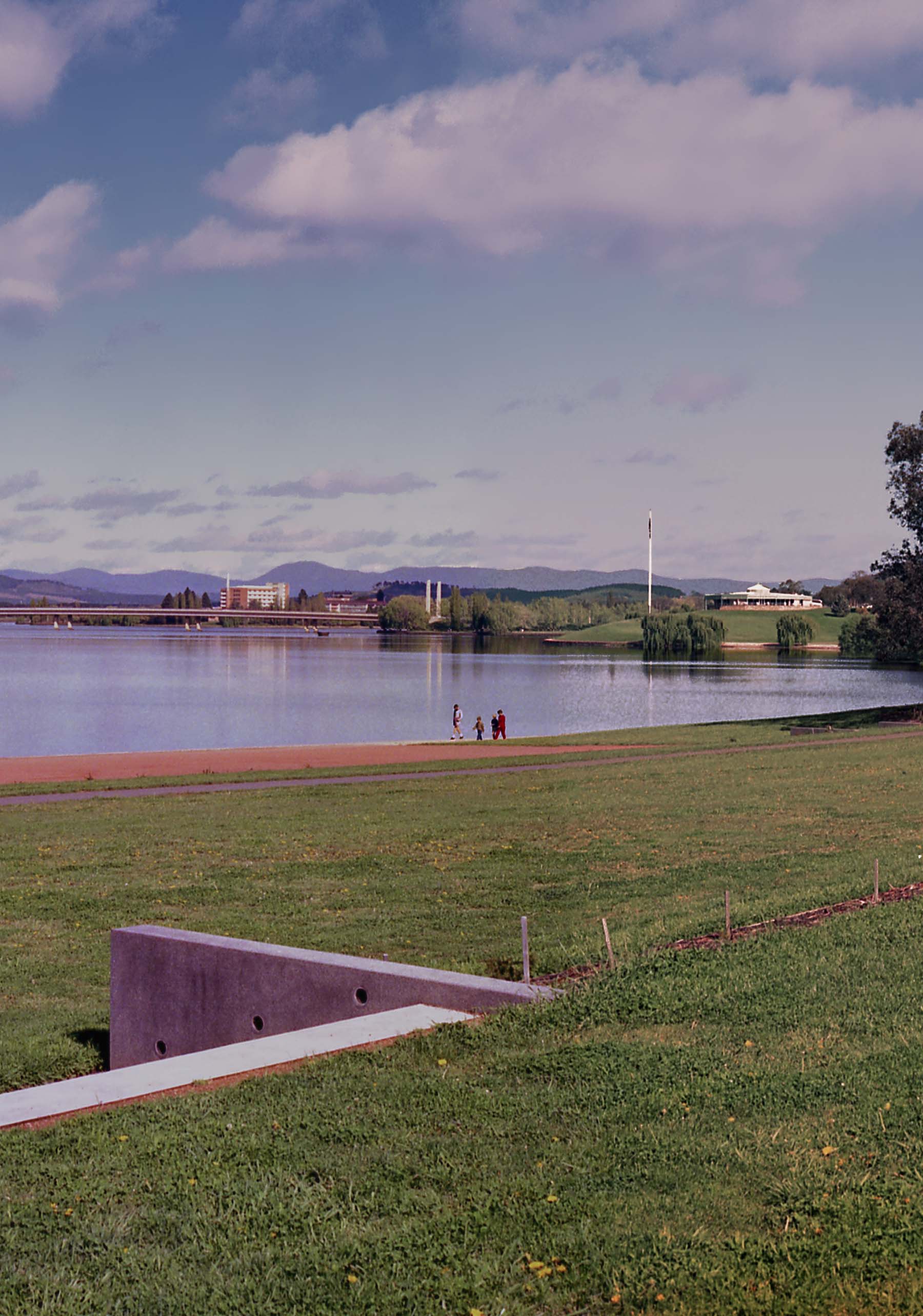 Pedestrians walking along the shoreline of Lake Burley Griffen in Canberra.